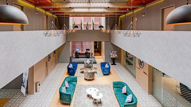 A spacious lobby with a central seating area, a reception desk, and a staircase leading to an upper level. - KALI Ciudadela Mexico City (Mexico City)
