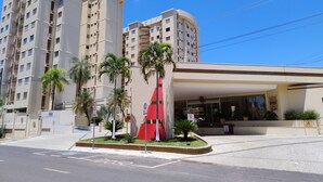 A hotel with a modern design, featuring a curved entrance and a prominent red sculpture in the center. - Royal Residence - Achei Férias (Caldas Novas)
