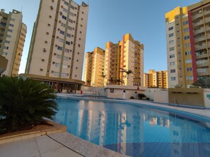 A swimming pool surrounded by high-rise residential buildings. - Vitória das Thermas - Achei Férias (Caldas Novas)