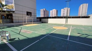 An outdoor basketball court with a net, a chair, and a ladder. - Thermas dos Bandeirantes - Achei Férias (Caldas Novas)