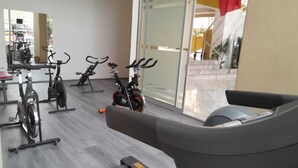 Un gimnasio con bicicletas estáticas y una cinta de correr.