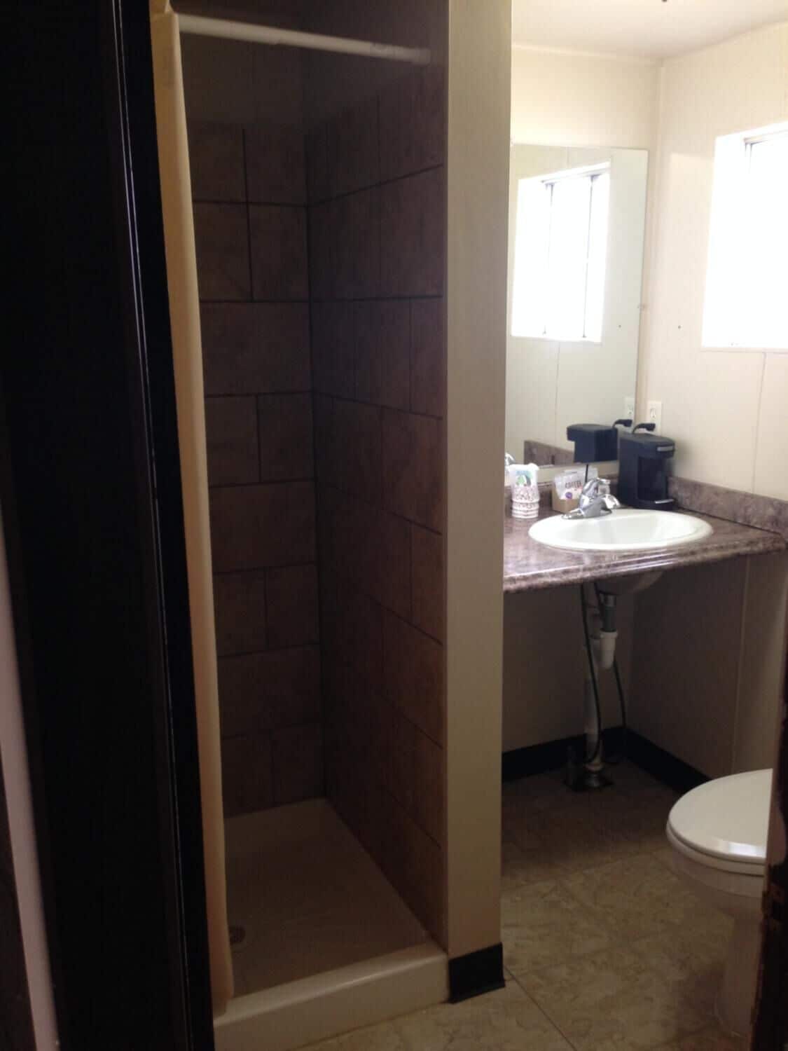 Une salle de bain avec une douche, un lavabo et des toilettes.