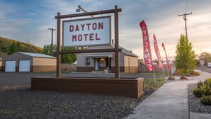 A motel sign with a building in the background. - Dayton Motel (Dayton)
