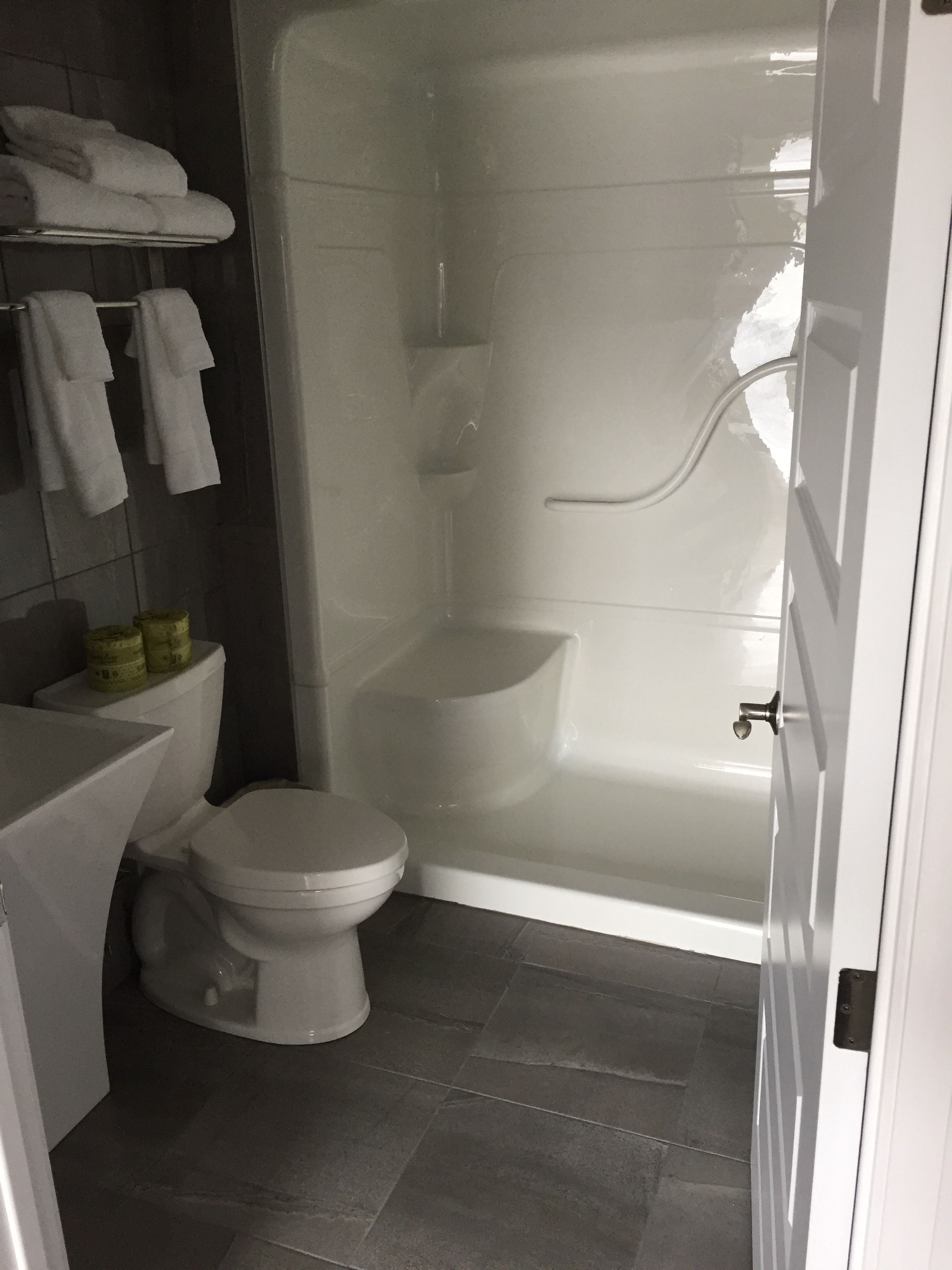 Une salle de bain moderne équipée de toilettes, d’une baignoire et d’un espace douche.