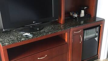 Un meuble de rangement en bois comprenant un téléviseur à écran plat, un four à micro-ondes et un petit réfrigérateur.