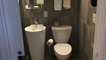 Un baño pequeño con lavamanos, inodoro y espejo.