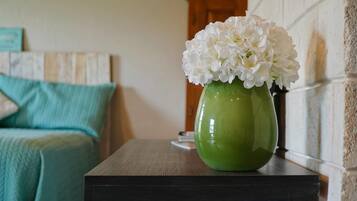 Relax in a serene space with a comfortable bed and a beautiful vase of white flowers.