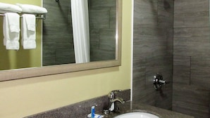 Une salle de bain avec un lavabo, un miroir et une douche.