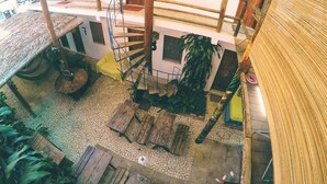 A multi-level building with a spiral staircase, numbered rooms, and a thatched roof area. - Buddy's Hostel e Pousada (Itacaré)