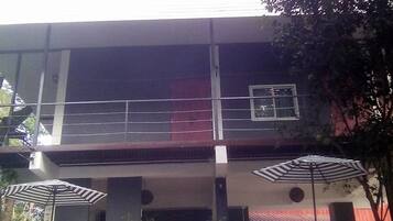 Un bâtiment à deux étages doté d’un balcon, de plantes en pot et d’une enseigne à l’avant.