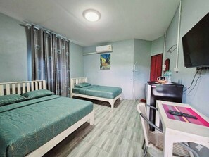 Una habitación con dos camas, un escritorio, una silla, un equipo de aire acondicionado y una televisión.