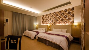 A hotel room with two beds, a desk, and a chair. - Wogo Hotel (Yilan)