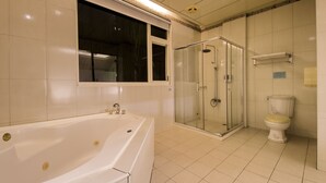 A bathroom with a bathtub, a glass-enclosed shower, and a toilet. - Wogo Hotel (Yilan)