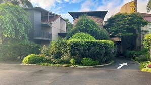 A building with a curved facade, surrounded by lush greenery and a clear sky. - Wogo Hotel (Yilan)