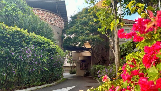A pathway leading to a building with a stone facade and a covered entrance. - Wogo Hotel (Yilan)