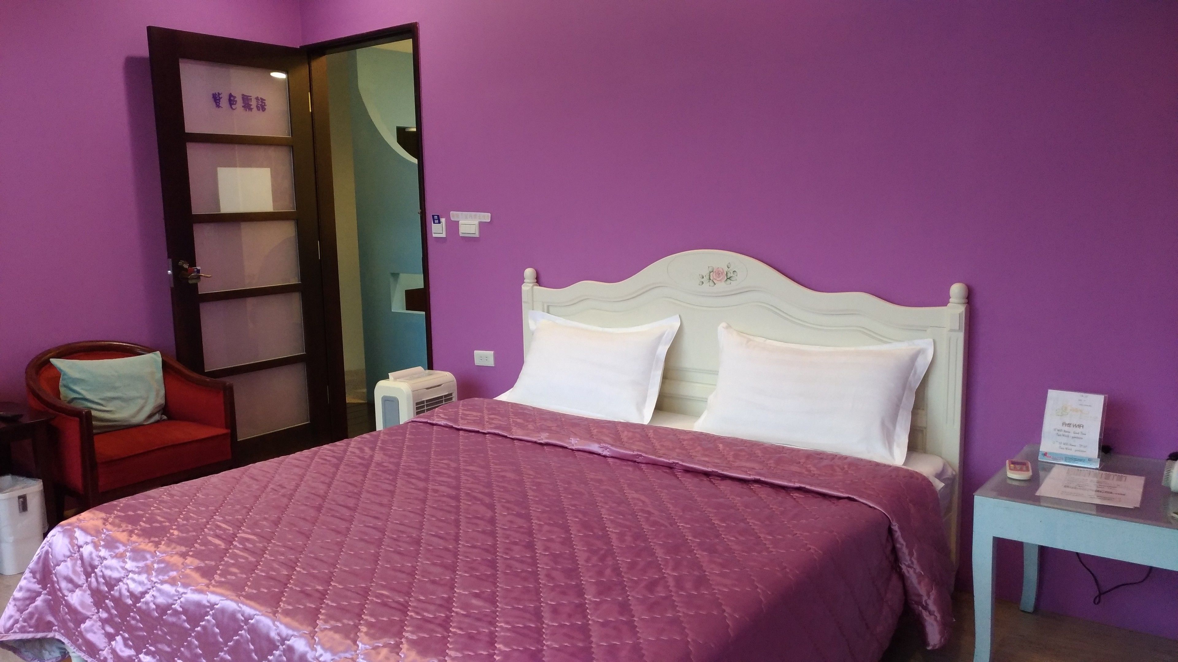 Une chambre à coucher avec un lit, une chaise, un bureau et un miroir.