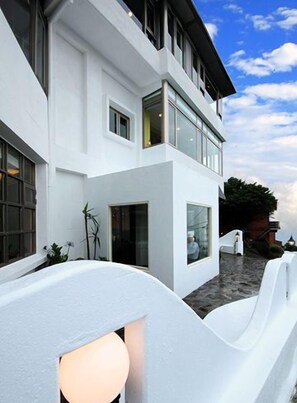 Un moderno edificio de dos pisos con amplias ventanas y fachada blanca.