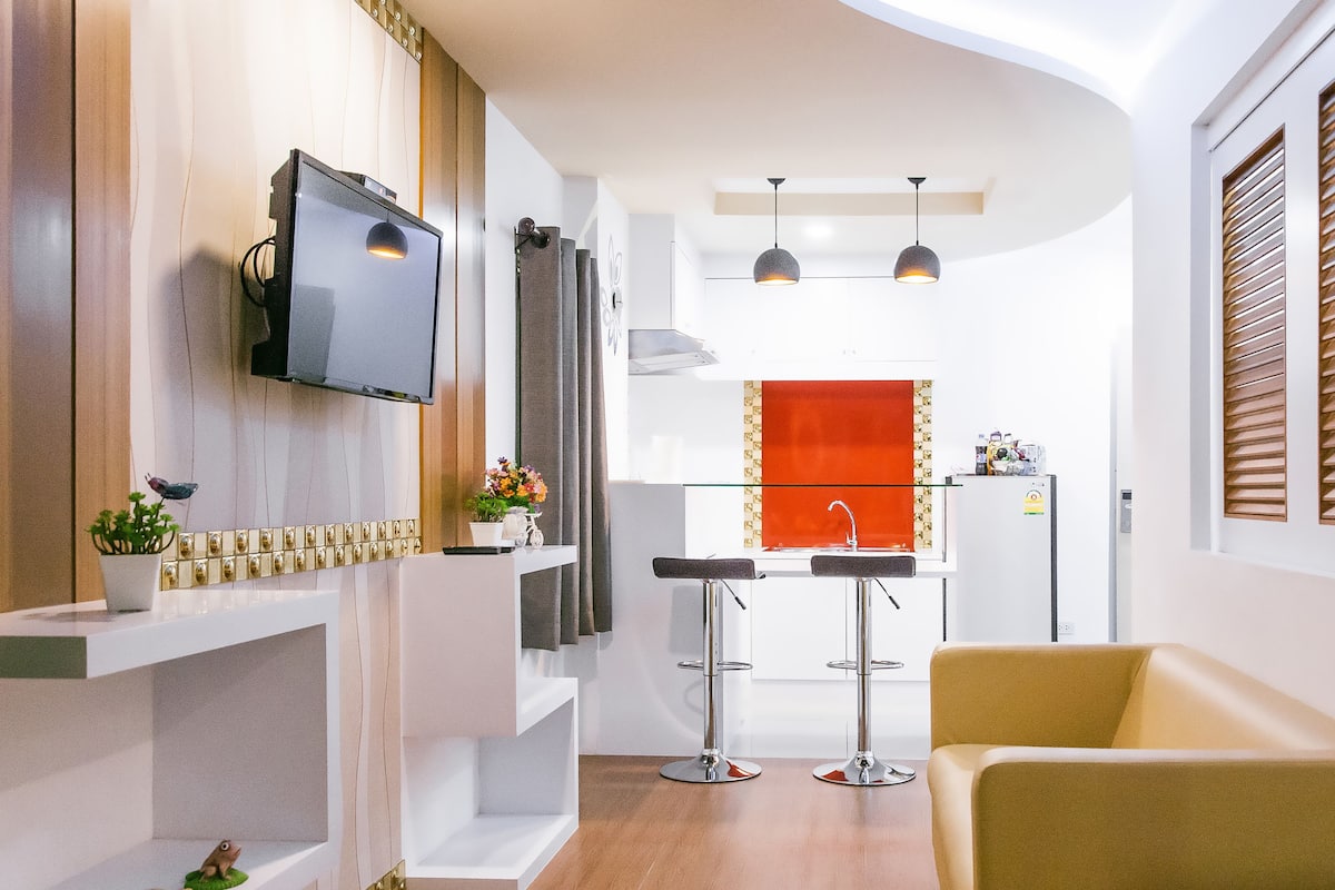 A modern kitchen with a built-in oven, a sink, and a window with blinds.
