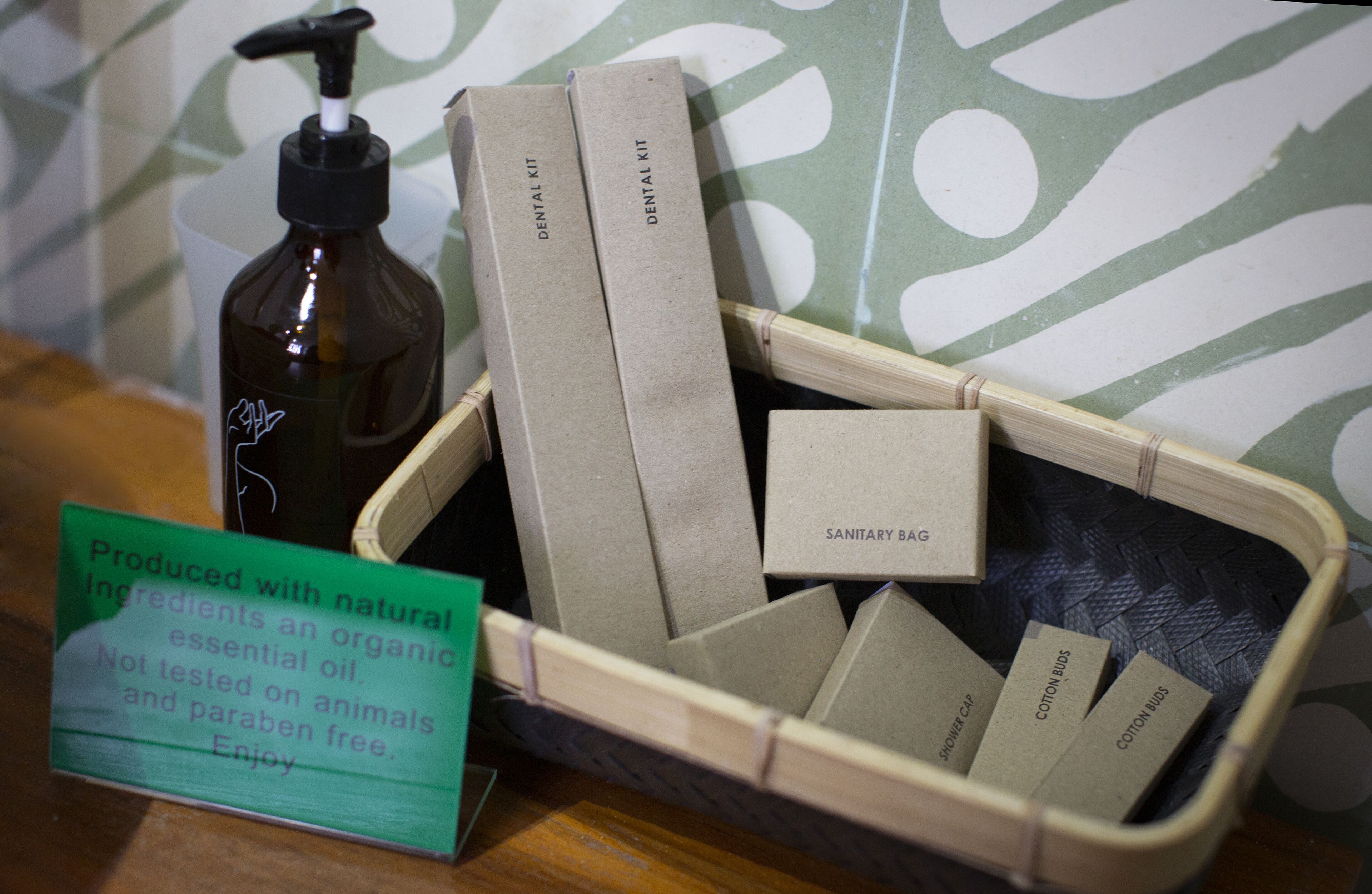 A display of natural ingredients and organic products, including a bottle of essential oil and several bars of soap labeled with their uses.