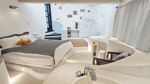 A modern bedroom with a large bed, a bathtub, and a small sitting area. - Gold Stone Crescent Moon Light (New Taipei City)