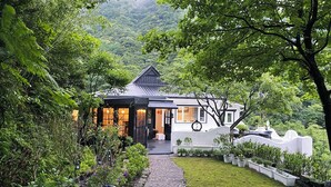 A house with a garden pathway leading to the entrance, surrounded by lush greenery and trees. - Gold Stone Crescent Moon Light (New Taipei City)