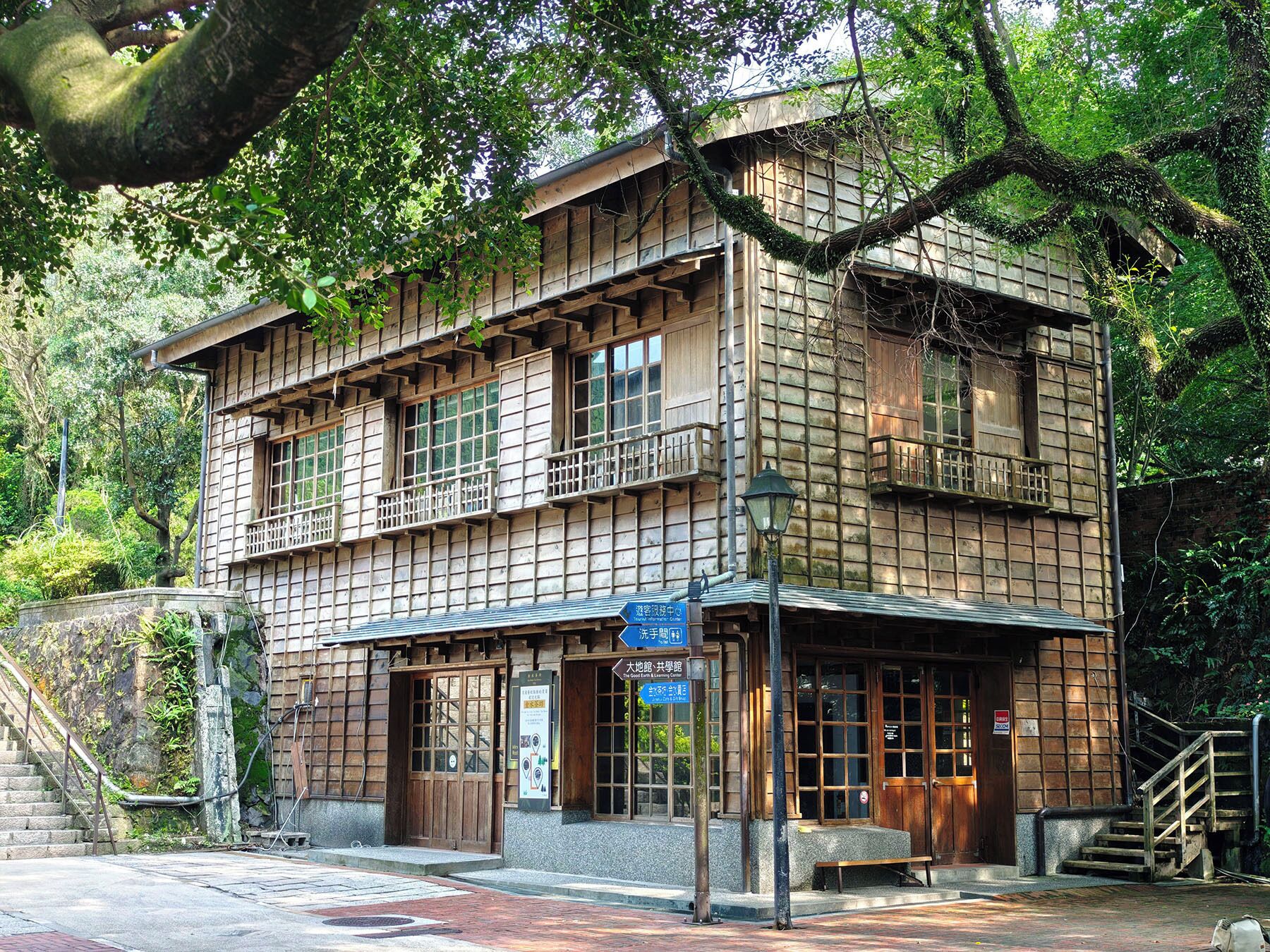 A traditional Japanese building with a wooden facade, multiple windows, and a small entrance with a wooden door.