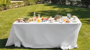 Une table dressée à l’extérieur, avec un bâtiment en arrière-plan.
