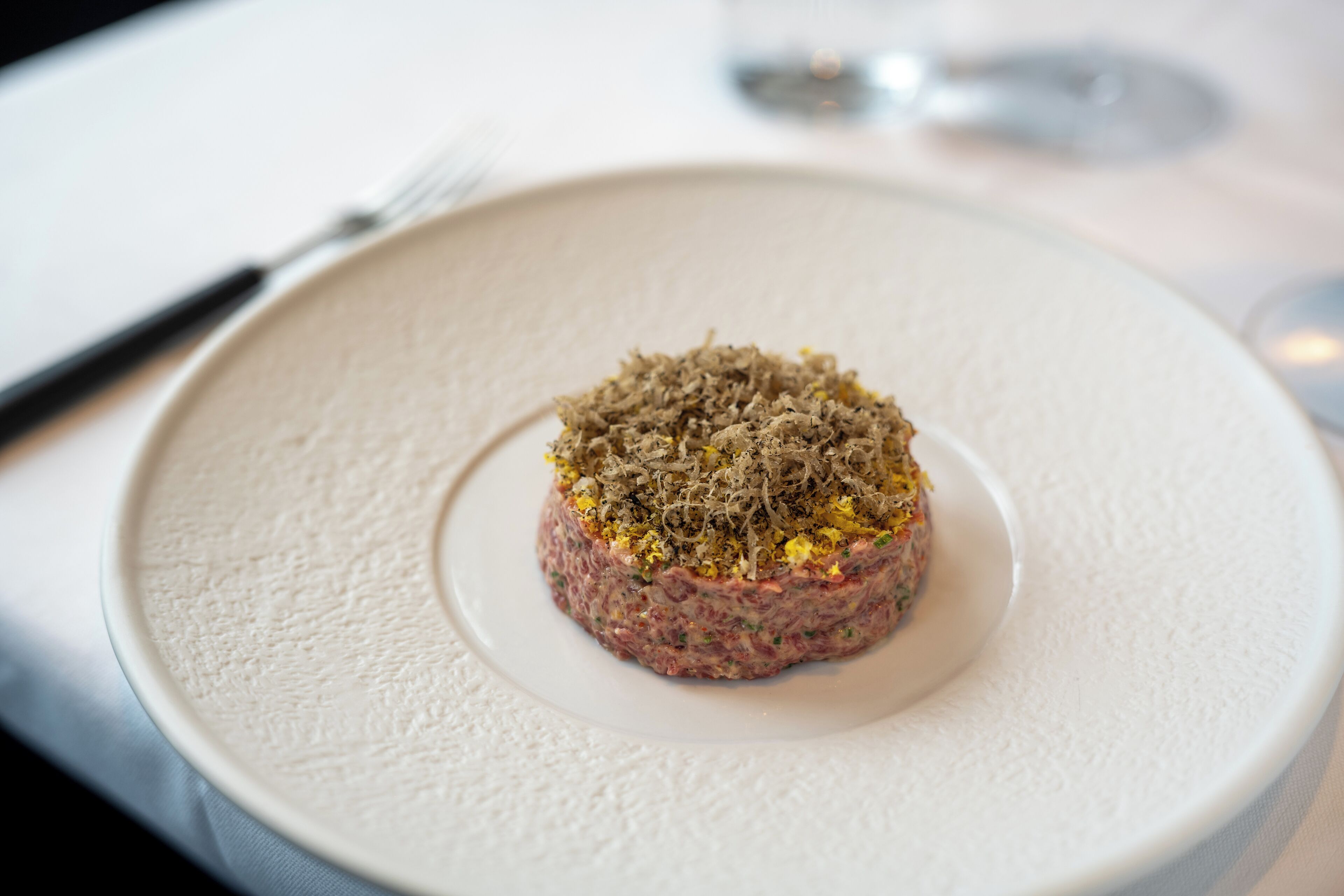 A dish on a white plate with a textured surface.