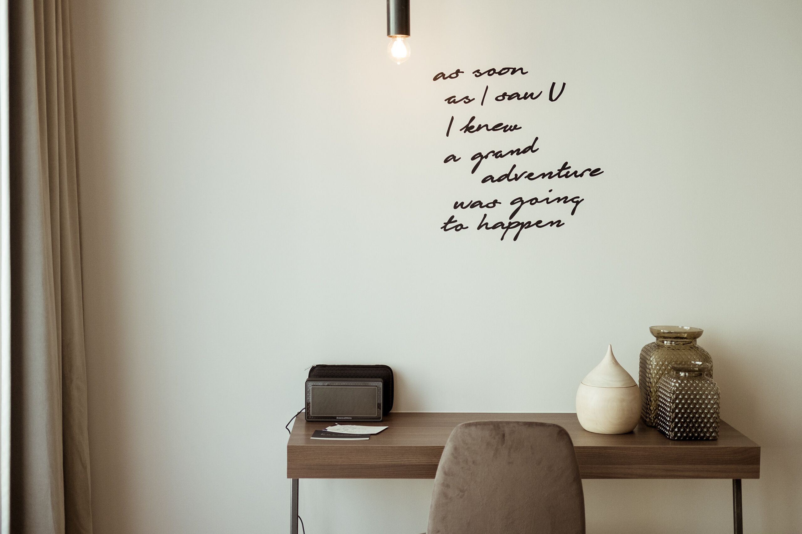 A desk with a lamp, a radio, and decorative vases.