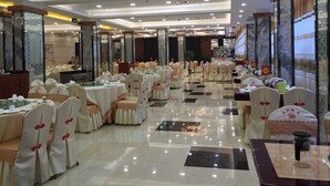 A banquet hall with round tables, chairs, and a polished floor. - Nantian Hotel (Liuzhou)