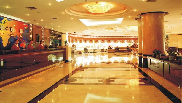A spacious lobby with a reception desk, seating area, and a large chandelier. - Nantian Hotel (Liuzhou)