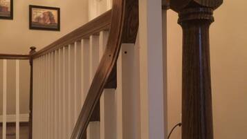 A wooden staircase with a white handrail and a dark wooden balustrade.