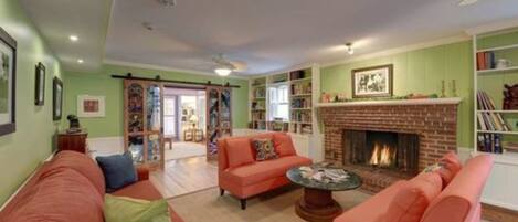A living room with a fireplace, a sofa set, and a bookshelf.
