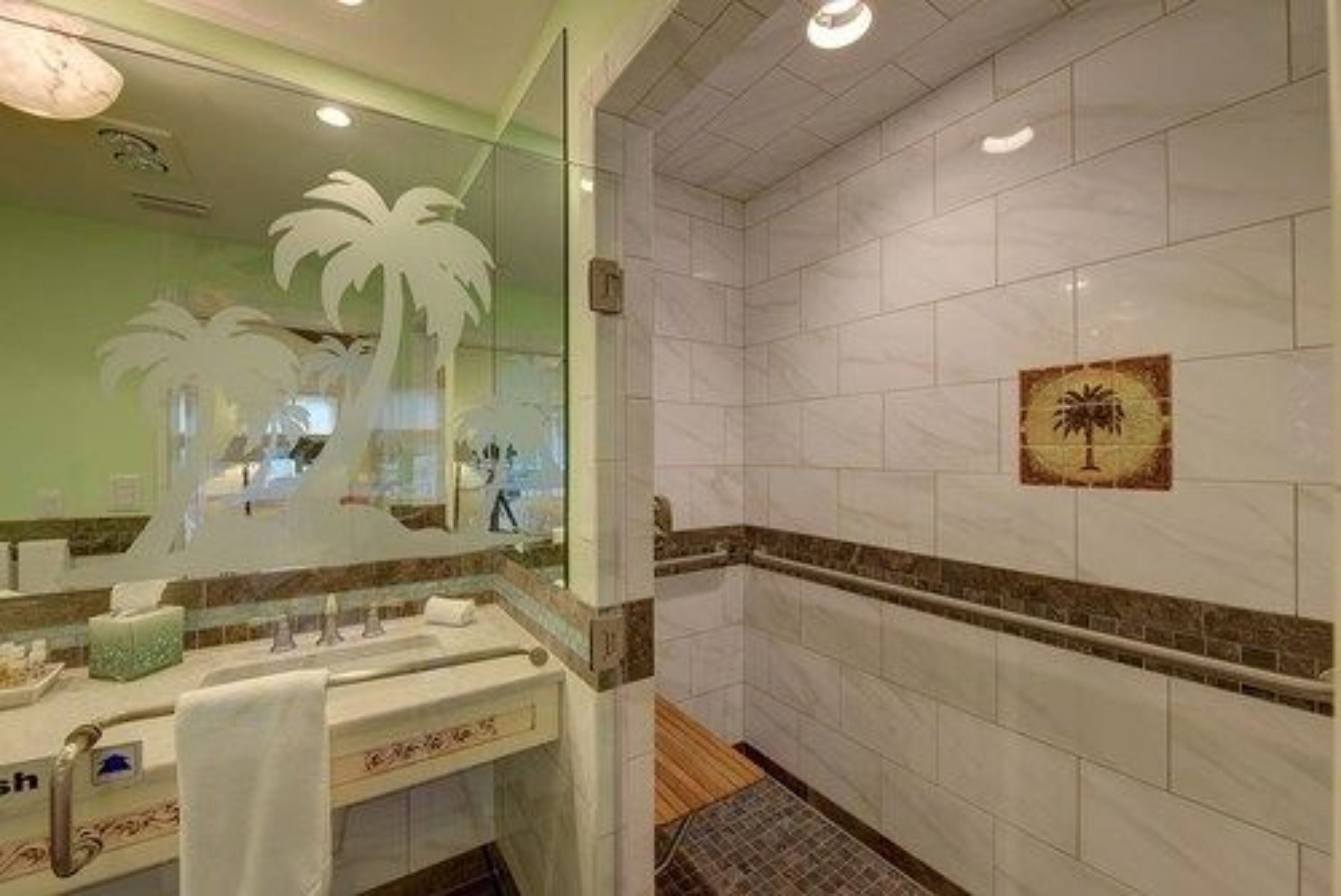 Een badkamer met een grote spiegel, een wastafel en een douche.