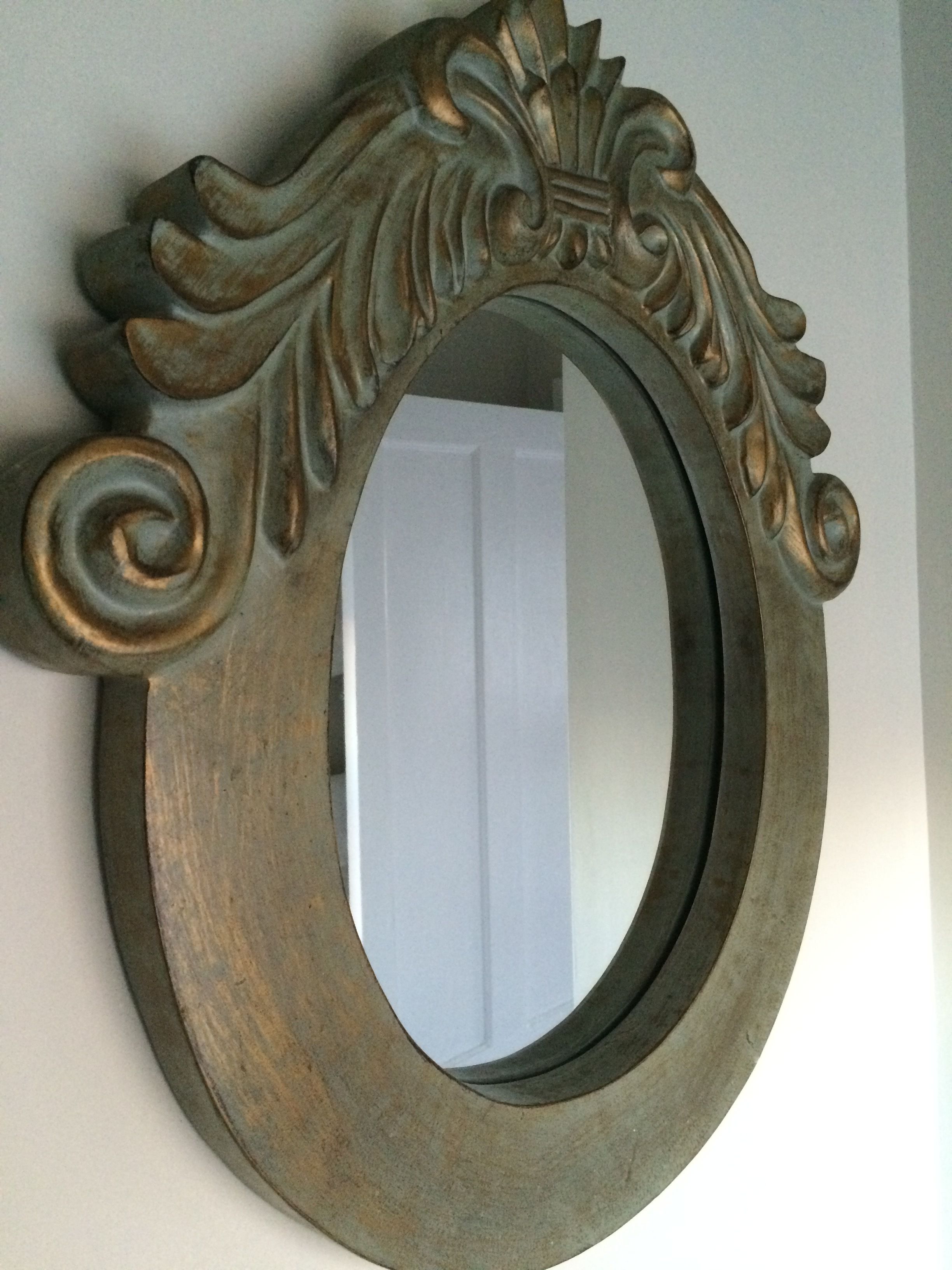 Un espejo de pared con un diseño vintage y ornamentado.