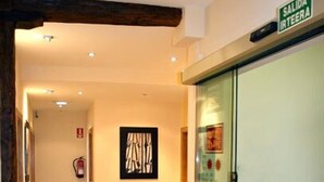 Un pasillo con piso de madera, una silla, una computadora portátil y un cartel que dice "SALIDA IRTEERA".