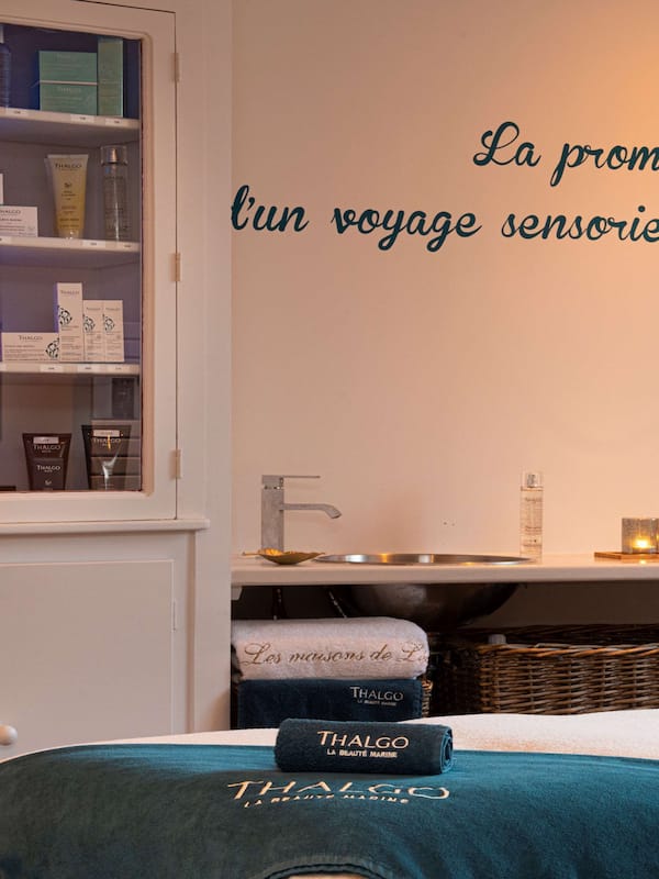 Experience relaxation and comfort in this thoughtfully designed room, featuring a neatly arranged shelf with toiletries and a towel rack.