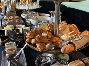 Ein reichhaltiges Buffet mit verschiedenen Speisen, darunter Gebäck, Brot und Beilagen.