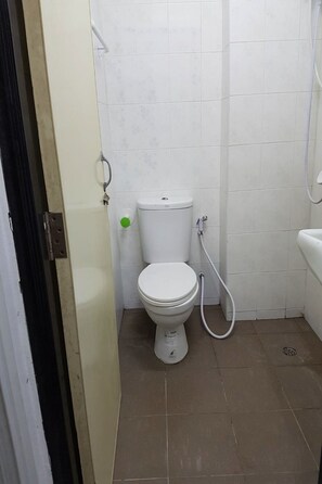 A small, clean bathroom with a toilet, a shower, and a sink. - Airportlink Lardkrabang Mansion (Bangkok)