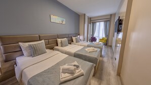 Una habitación de hotel con tres camas, un ventanal con cortinas, un cuadro en la pared y un televisor en la esquina.