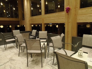 Un restaurante con paredes de madera altas, varias mesas y sillas.