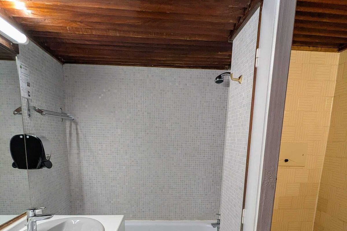 A compact bathroom with a white sink, a bathtub, and a toilet.