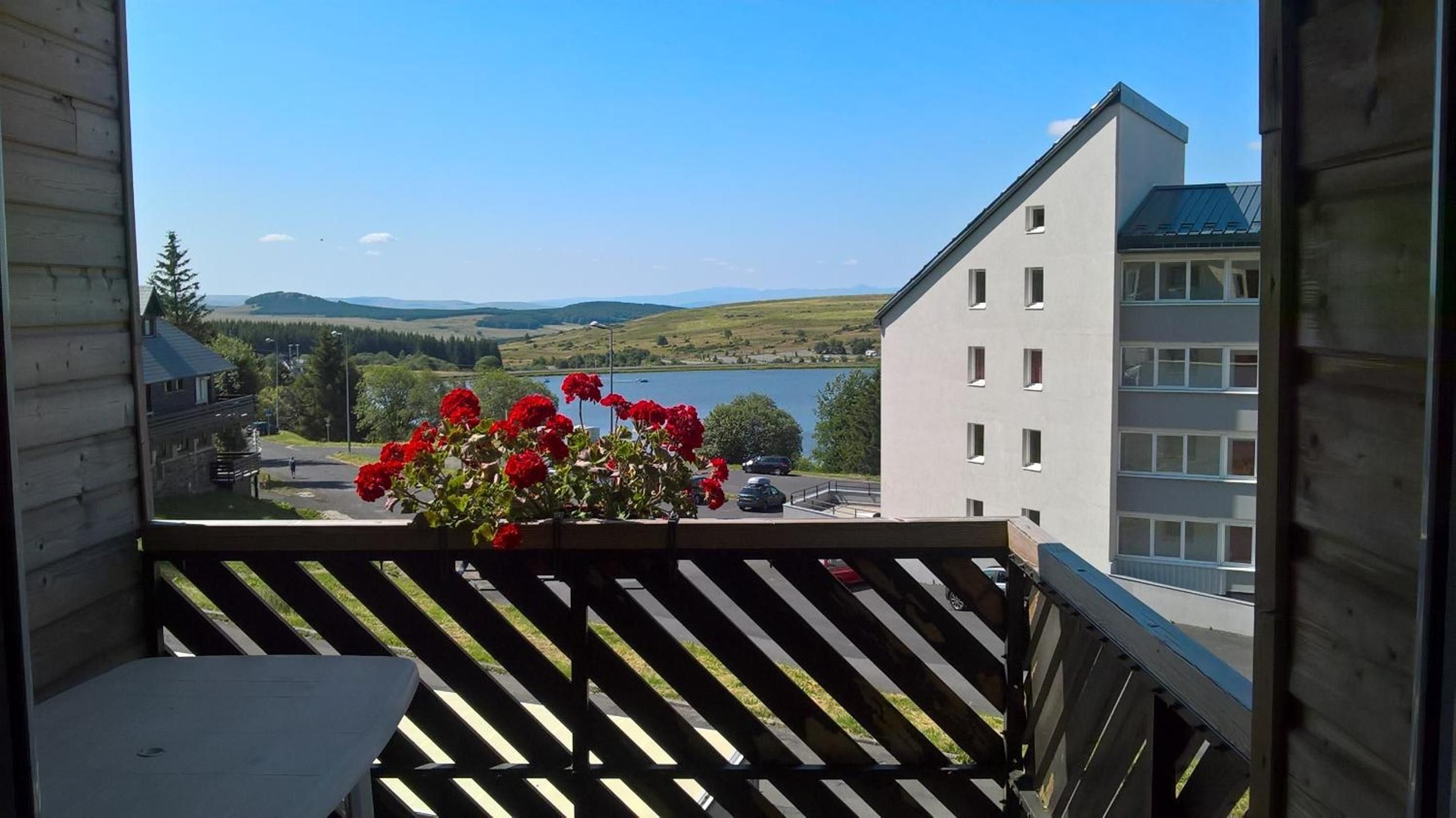 A balcony with a view of a lake, buildings, and a clear sky.