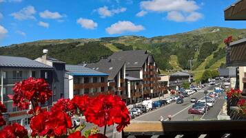 A street view with buildings, cars, and a mountainous backdrop.
