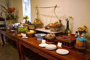 A buffet table with various dishes and condiments, surrounded by decorative items and plants.