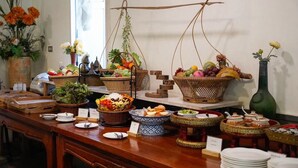 A buffet table with various food items and decorative elements. - The Antique Riverside (Ban Pong)