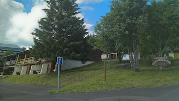 Zona residencial con una casa identificada como 'Residence Champbourgquet', un cartel de estacionamiento y un edificio con techo inclinado.