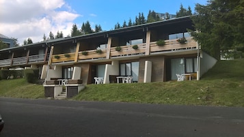 Un edificio moderno con techo plano, ventanas grandes y balcones de madera.