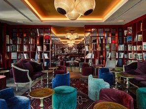 Eine Bibliothek mit Bücherregalen, einer Bar und Sitzgelegenheiten.