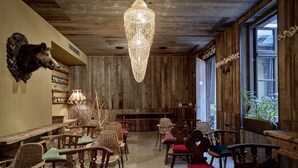 Un intérieur rustique avec des murs en bois, un lustre et différents types de sièges.